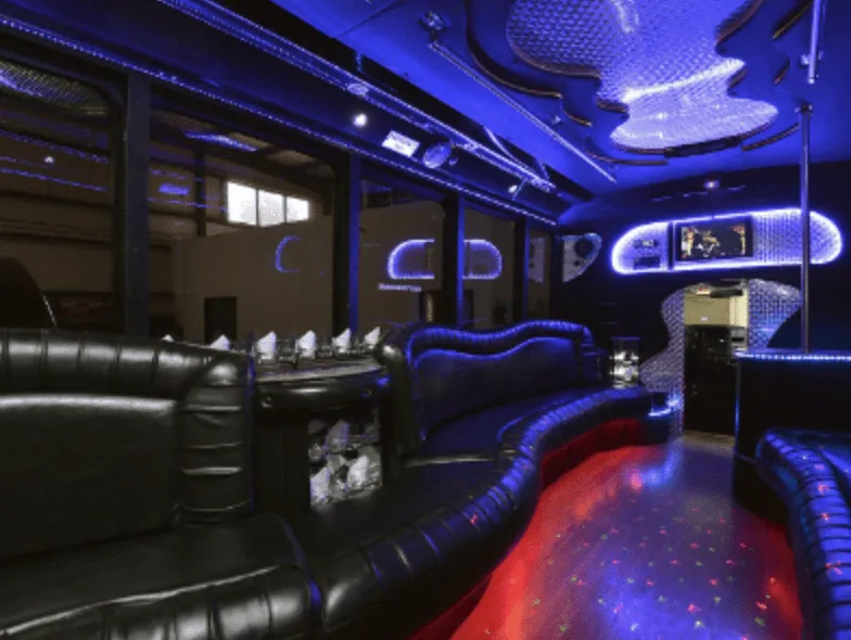 Black GMC party bus interior with perimeter lounge seating, sofa-style seating and LED accent lighting for party bus rental Black GMC party bus interior with perimeter lounge seating, sofa-style seating and LED accent lighting for party bus rental