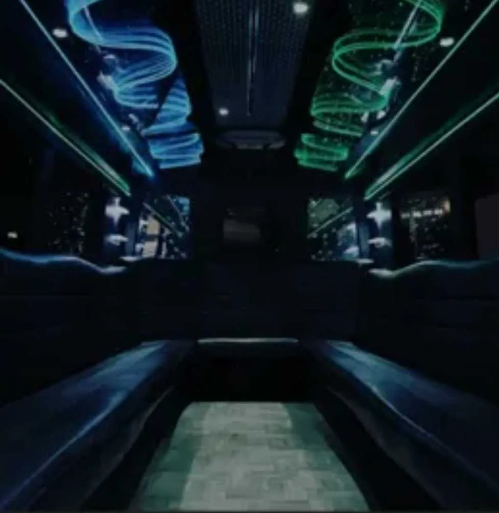 Black Party Bus interior with perimeter lounge seating and LED accent lighting for party bus rental