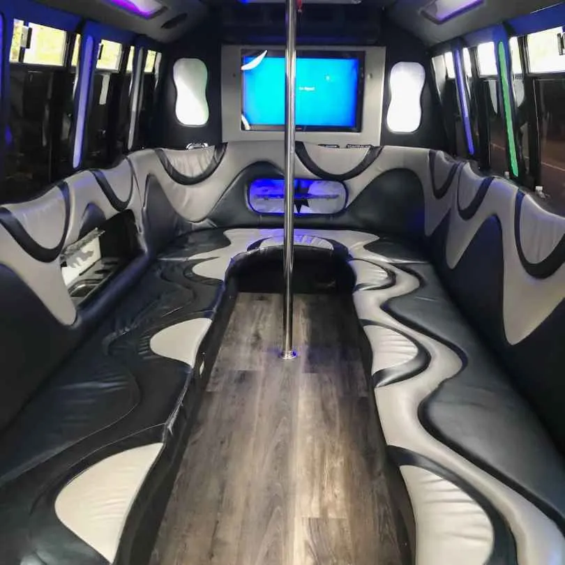 Ford Party Bus interior with perimeter lounge seating, LED accent lighting and wood-look flooring for party bus rental Ford Party Bus interior with perimeter lounge seating, LED accent lighting and wood-look flooring for party bus rental