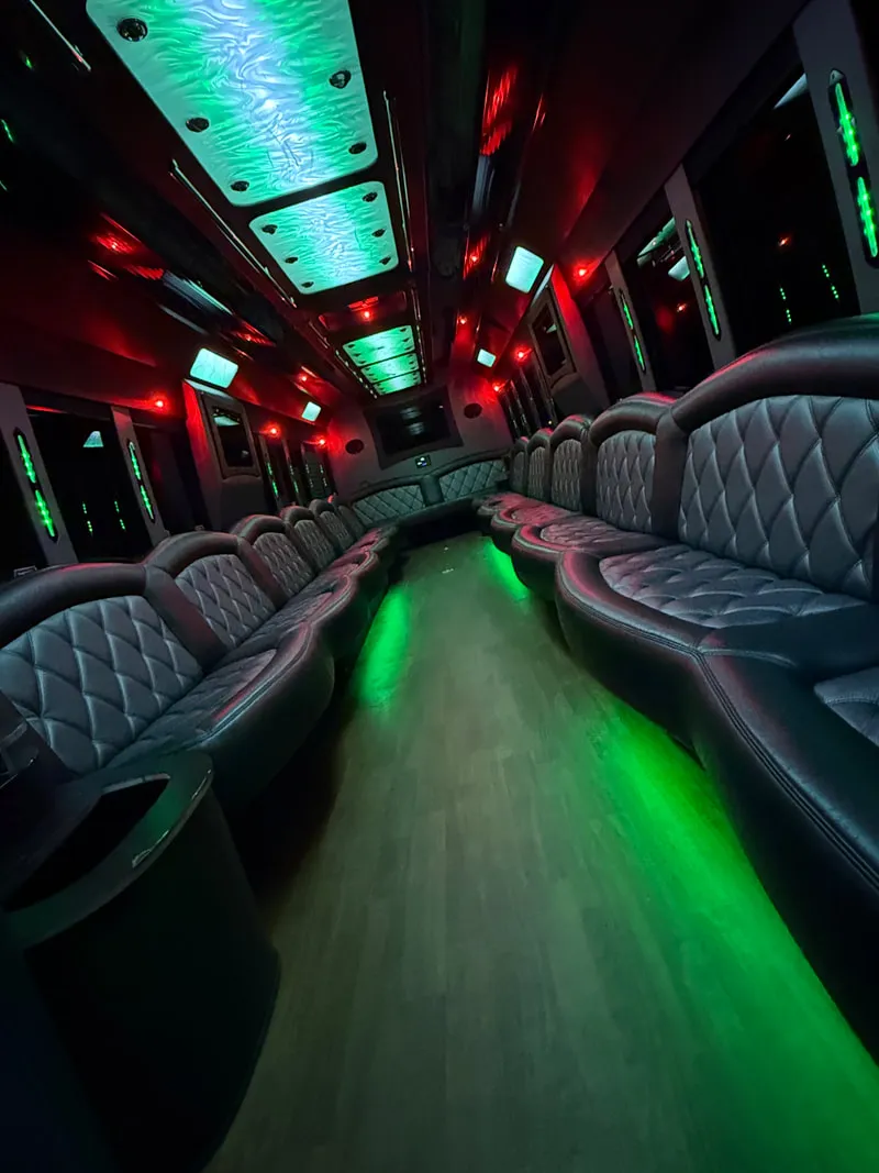 Freightliner Party Bus interior with perimeter lounge seating, LED ceiling lighting and wood-look flooring, photo 10 for party bus rental
