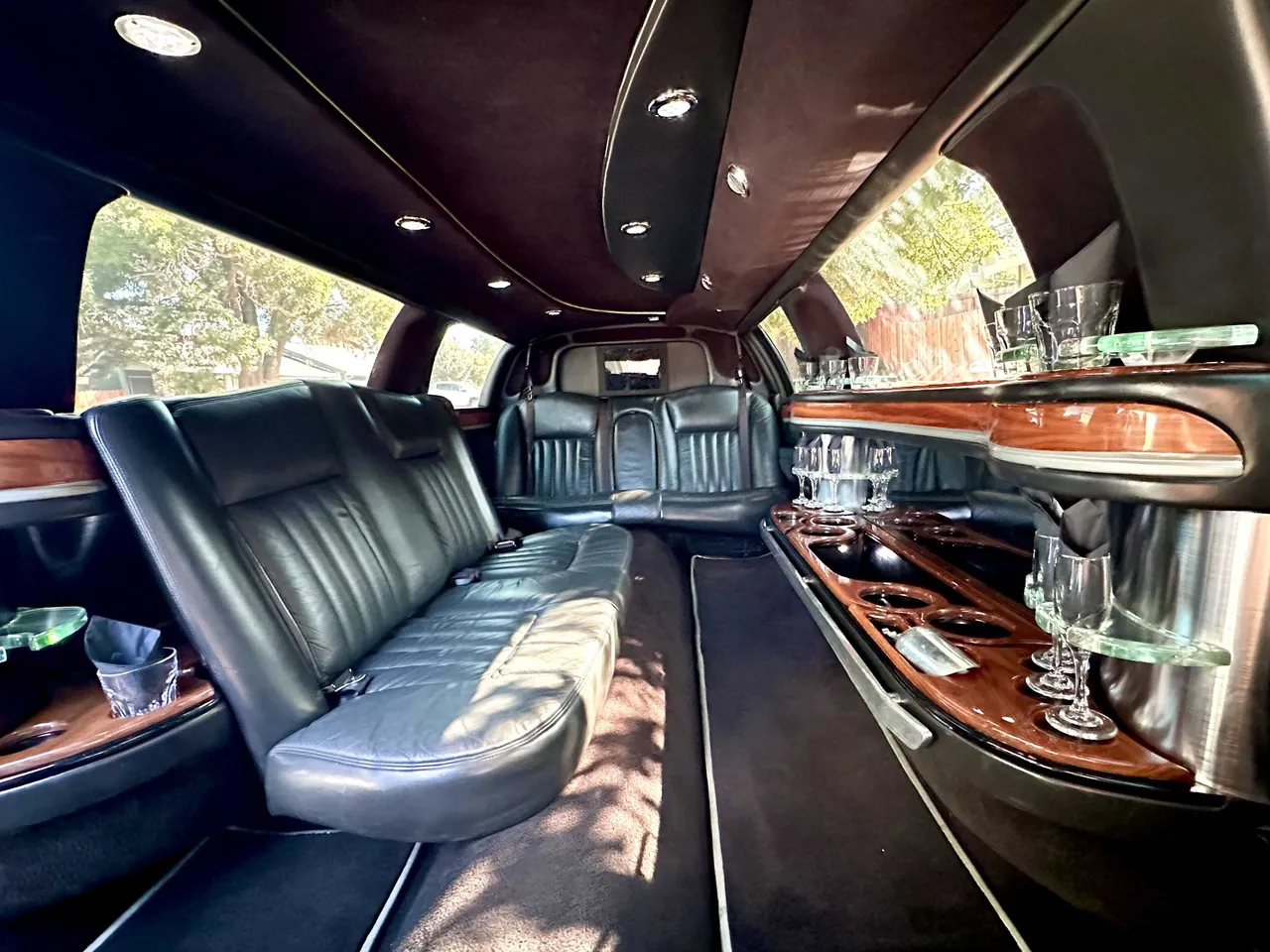 Lincoln Towncar Limo interior with perimeter lounge seating, cup holders and bar area, photo 4 for limo rental in Beale Afb, CA Lincoln Towncar Limo interior with perimeter lounge seating, cup holders and bar area, photo 4 for limo rental in Beale Afb, CA