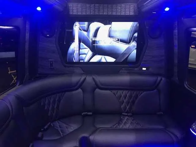 Mercedes Party Bus interior with sofa-style seating, LED accent lighting and TV screens for party bus rental in Alameda County, CA