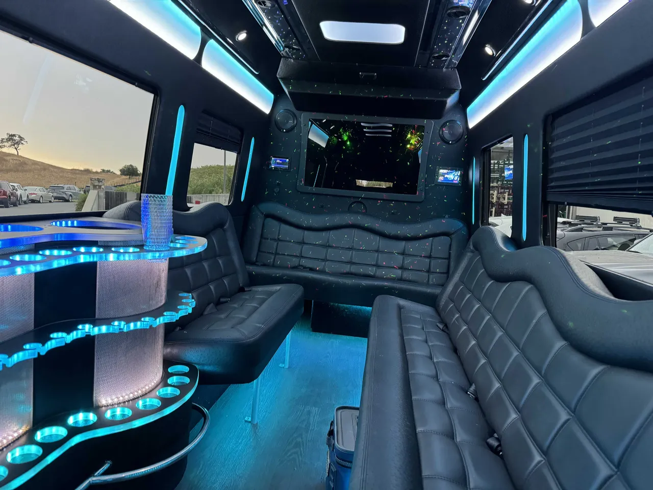 Mercedes Party Bus interior with perimeter lounge seating, window shades and LED accent lighting for party bus rental in Alameda County, CA