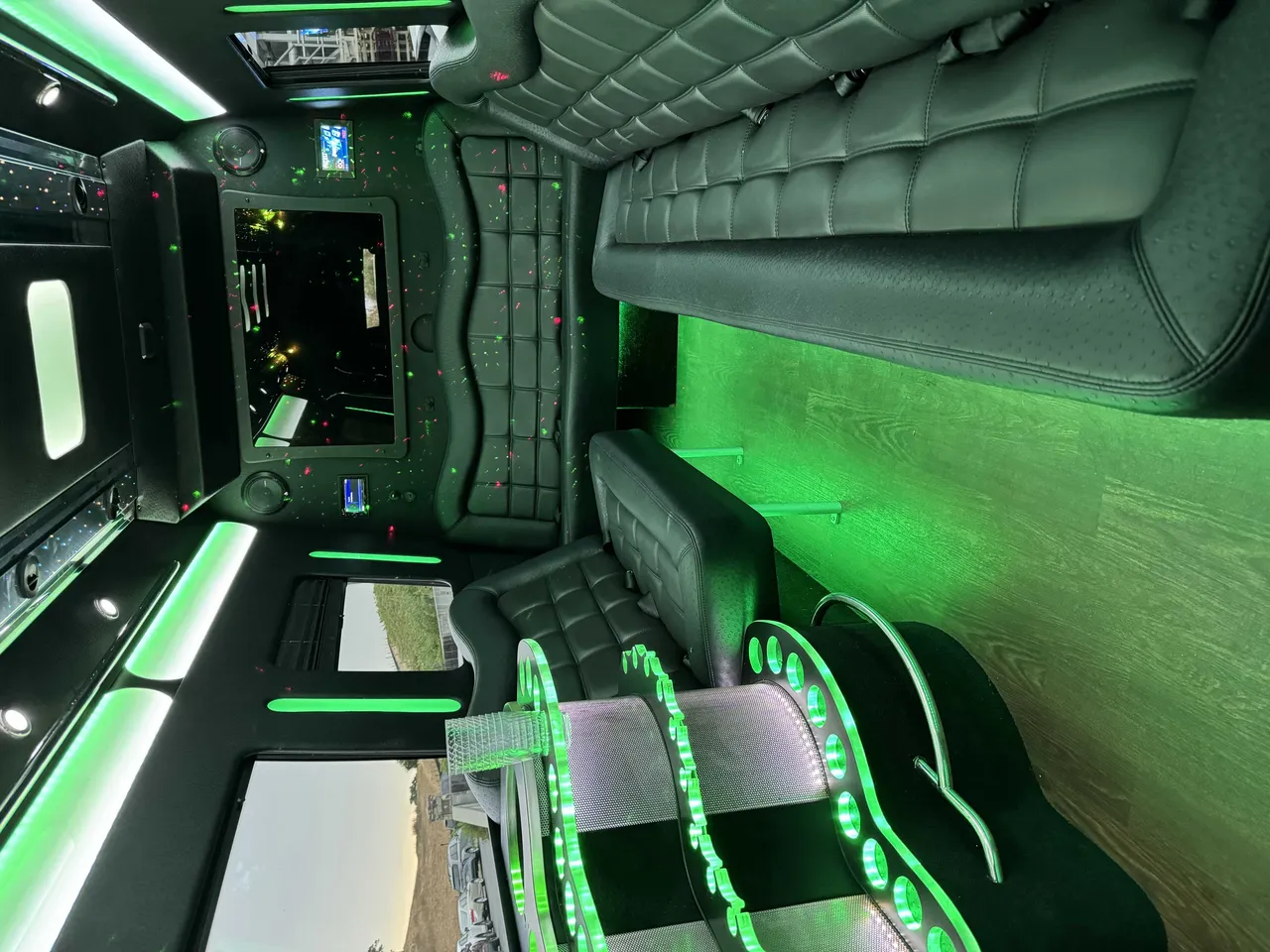 Mercedes-Benz Party Bus interior shot — perimeter lounge seating, LED accent lighting and wood-look flooring