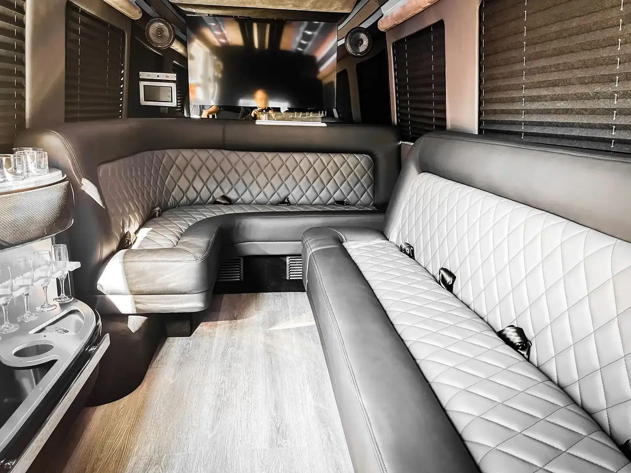 Mercedes-Benz Sprinter Limousine Mercedes-Benz Sprinter Limousine interior with perimeter lounge seating, window shades and wood-look flooring for party bus rental