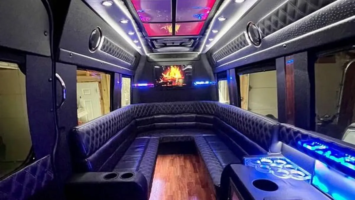 Mercedes-Benz Sprinter XL interior with perimeter lounge seating, sofa-style seating and cup holders for party bus rental