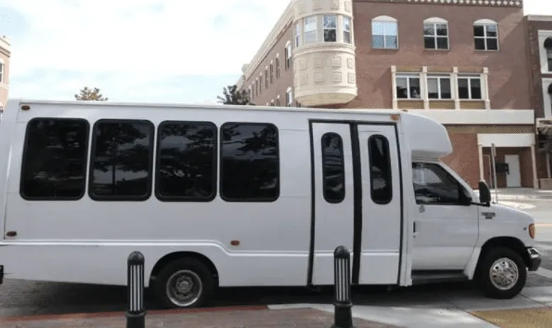 White 16 Passenger Party Bus exterior with tinted windows for party bus rental in Madera County, CA White 16 Passenger Party Bus exterior with tinted windows for party bus rental in Madera County, CA