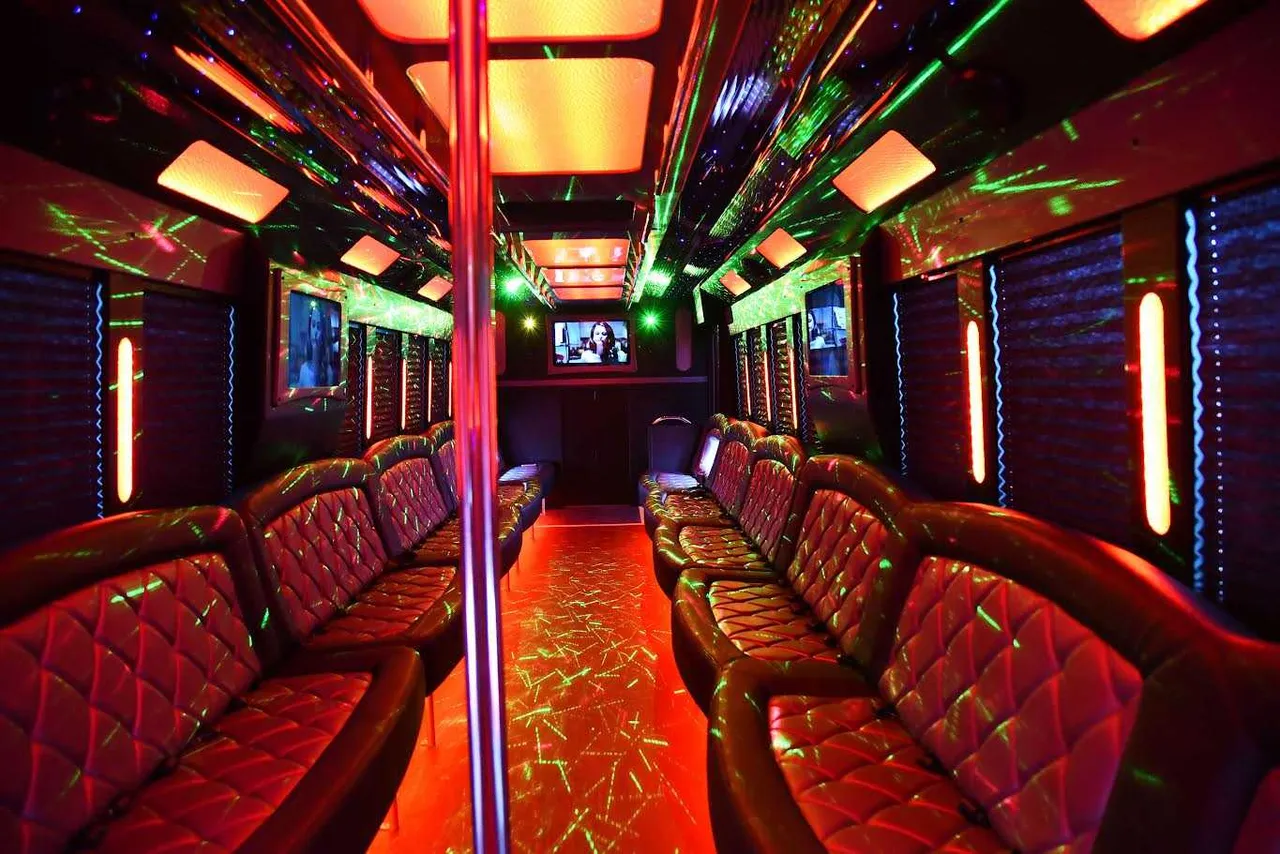 White 50 Passenger Party Bus 50 Passenger Party Bus interior with perimeter lounge seating, window shades and LED accent lighting for party bus rental