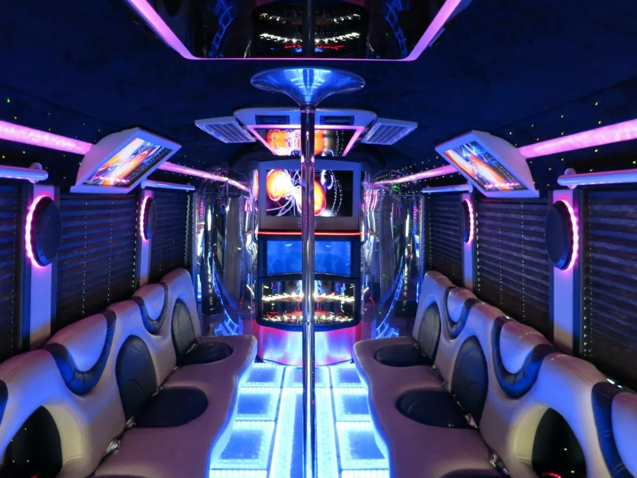 26 Passenger Party Bus interior with perimeter lounge seating, window shades and LED accent lighting for party bus rental in Arnold, CA