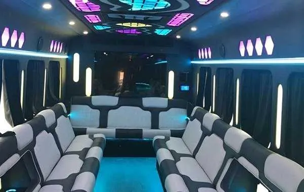 Party Bus White interior shot — perimeter lounge seating, window shades and LED accent lighting