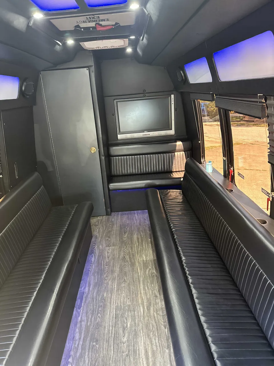 Small party bus interior with perimeter lounge seating, LED accent lighting and LED ceiling lighting for party bus rental Small party bus interior with perimeter lounge seating, LED accent lighting and LED ceiling lighting for party bus rental