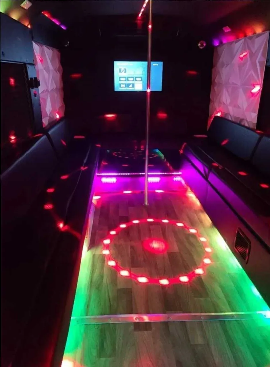 Tuxedo Party Bus interior with perimeter lounge seating, LED accent lighting and lit dance floor for party bus rental